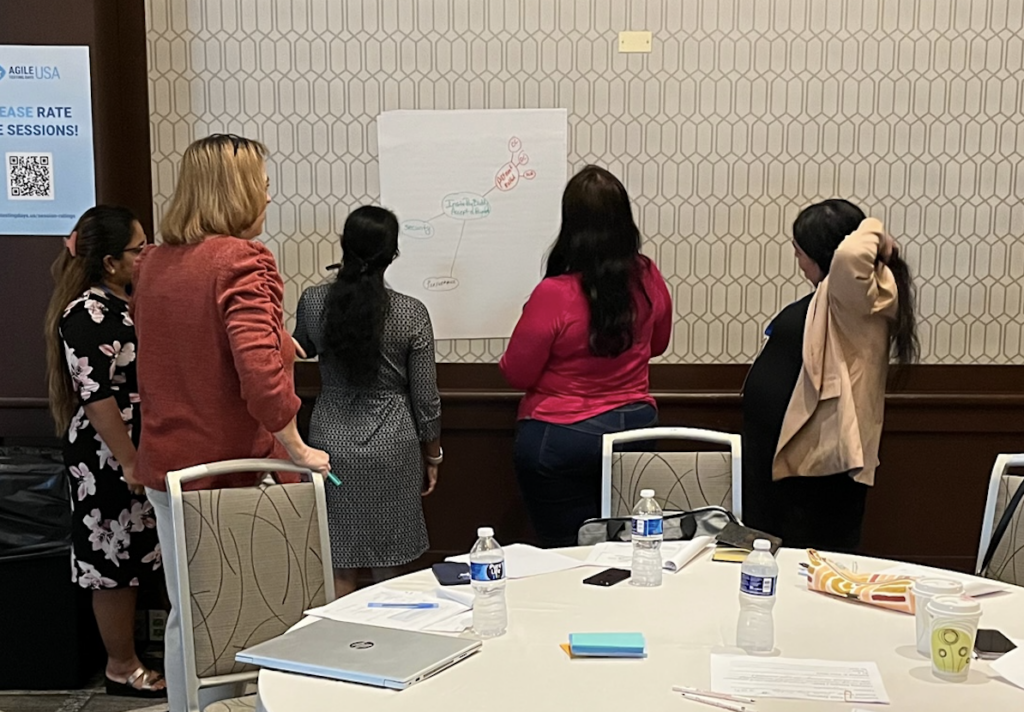 Group collaborating on a tutorial exercise at a flip chart