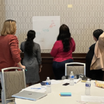 Group collaborating on a tutorial exercise at a flip chart